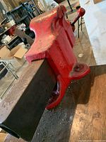 Side view of large red bench vise mounted to bench