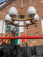 Front view of six-light fixture showing frosted globes and wood accents