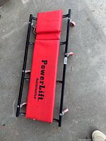 Full view of creeper showing padding, frame and casters