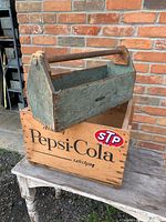 Overall view of both items: green tote resting inside Pepsi crate