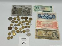 Overall view showing coin collection in plastic case, loose coins and four banknotes
