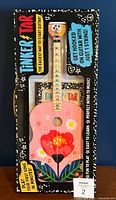 Front of boxed Tinker Tar guitar showing product and branding