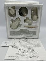 Styrofoam packaging showing individual figurine pieces and instruction sheet