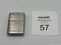 Lighter closed beside lot tag showing size and front engraving