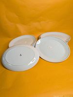 Stack of white Steelite entrée plates, top and bottom views