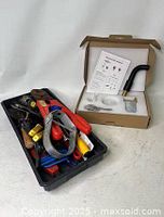 Tray of assorted tools next to boxed faucet kit