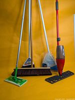 All four cleaning tools standing upright against yellow background