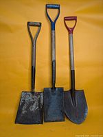 All three shovels standing upright against backdrop