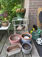 full lot on deck: nesting tables stacked with green glazed pot on top, additional pots grouped