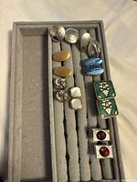 Front view of all eight cufflink pairs in tray