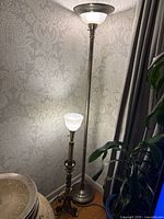 Tall and shorter torchiere lamps lit in corner