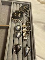 Front view showing all niello sterling pieces in presentation tray