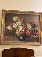 Framed oil painting on wall above furniture, shows size and frame style