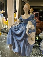 Front view of Royal Doulton Hilary figurine in blue dress holding hat