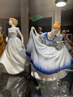 Front view of both Pamela and Megan figurines in display cabinet