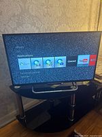 TV on stand displaying app icons menu