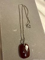 Full view of necklace showing box chain and amber pendant