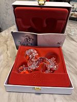 Dragon figurine inside open presentation case with certificate visible