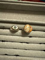 Front view of both rings showing eye and face motifs