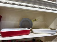 Shelf view of two baking dishes and cast iron skillet