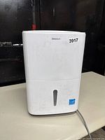 Front view of Shinco white dehumidifier with water tank window and lot number sticker