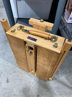 Closed easel showing brass hardware and carry handle