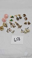 All nine pairs of vintage clip-on and screwback earrings displayed on white background