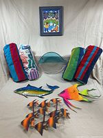 Group shot of all items—rolled towels, metal fish wall art, glass fish plate, framed print