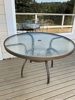 Overall view of round glass patio table on deck