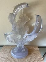 Front view of resin dolphin sculpture showing three dolphins leaping over wave