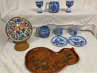 Group shot of all pottery, Spanish plate on stand, and wood tray