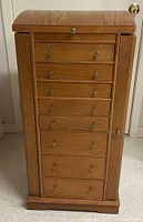 Front view closed showing seven drawers, brass-tone knobs, oak finish