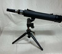 Side view of Tasco telescope mounted on table tripod
