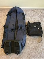 Full view of InGear blue rolling golf travel bag next to Kenneth Cole Reaction Nokia backpack