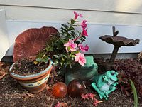 Overall lot showing frogs, planter, glass floats, birdbath, red leaf cast