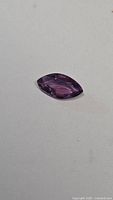 Front view of the marquis cut purple pink sapphire showing shape and color details.