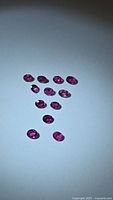 Natural untreated oval cut ruby lot arranged on white background showing color and cut.