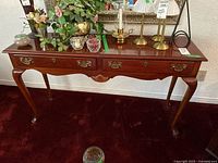 Front view of console table showing drawers and brass pulls