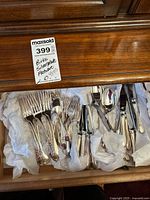Drawer view of entire flatware lot with MaxSold tag visible