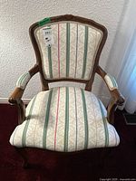 Front view of armchair showing upholstery pattern and wood frame
