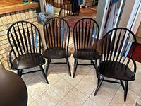 Four black wood veneer chairs aligned showing overall style and quantity