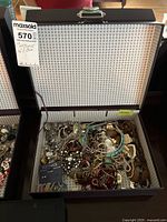 Open jewelry box showing large assortment of costume jewelry pieces