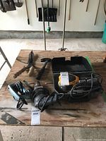 All items laid out: jig saw, hammer drill, sander in case, loppers, hammer