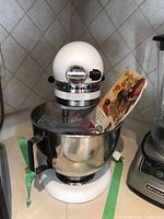 Front angle of KitchenAid mixer with bowl, beater, recipe book visible