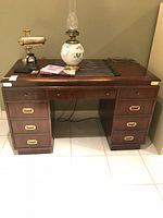 Front view of Kroehler wood desk with lamp and accessories on top