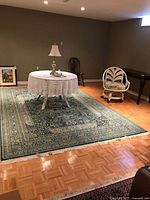 Full view of green oriental rug under table and lamp
