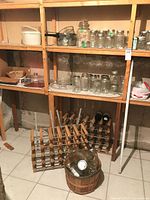 Overall lot on shelves showing wine racks, jars, basket