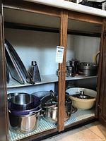 Cabinet view showing multiple cookware and bakeware items