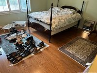 Bedroom view showing larger teal rug next to bed and smaller ivory rug near foot of bed