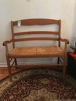 Front view of wooden bench with rush seat